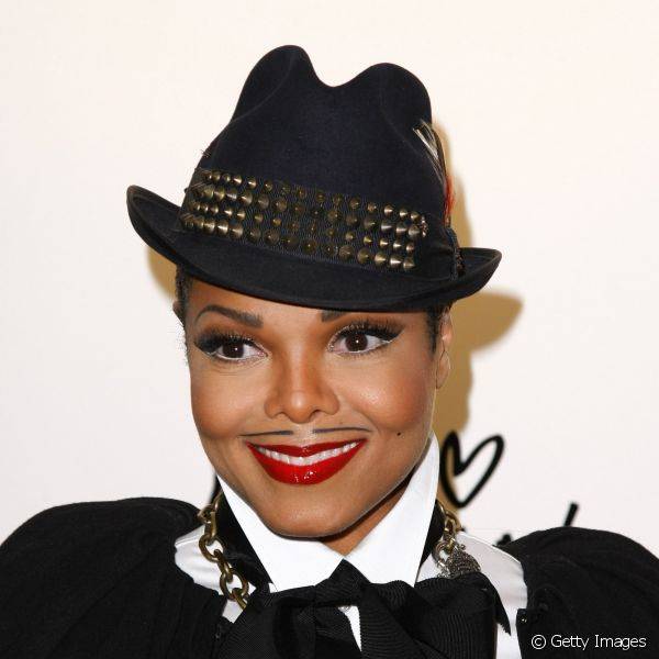 Janet Jackson criou um bigodinho de lápis para imitar o Rei do pop, mas manteve a feminilidade com om batom vermelho